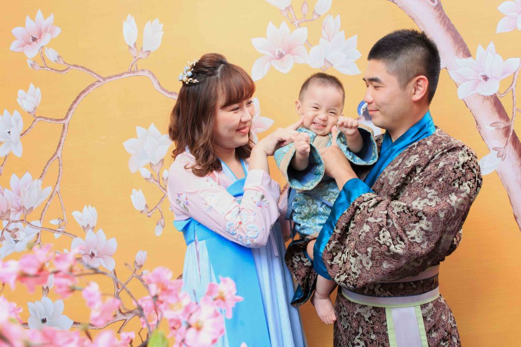 三代同堂家庭穿著和服風傳統服裝拍攝紀念合照，背景為紅色燈籠牆