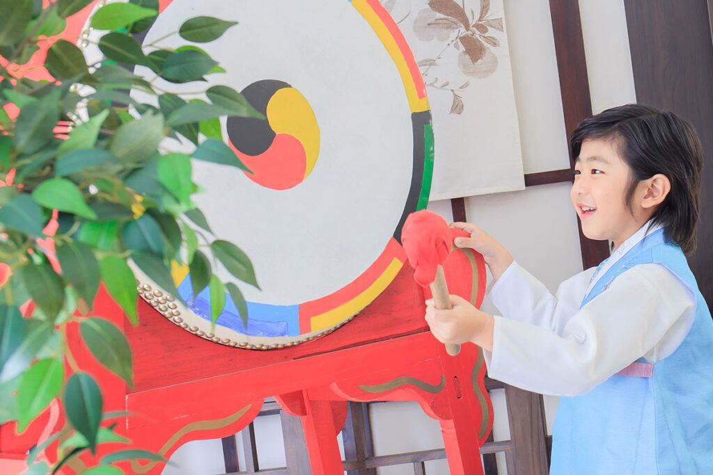 小朋友身穿韓服敲響狀元鼓祈求金榜題名的韓式啟蒙禮畫面