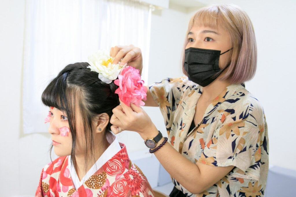 小村日和專業造型師為小朋友打理中式抓周髮型妝容的畫面
