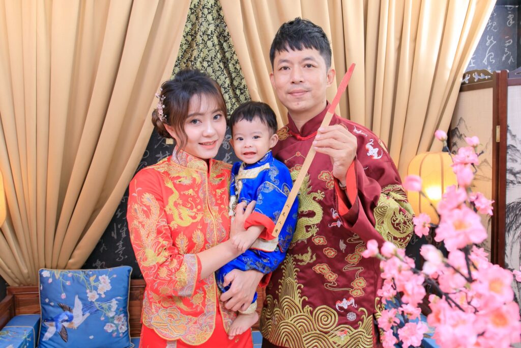 寶寶在紅色簽筒前抽取中式抓周祈願籤的可愛模樣