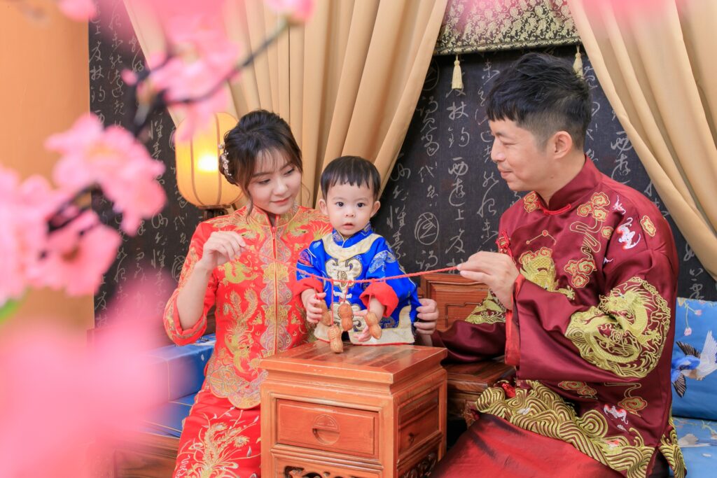 寶寶於中式抓周桌前伸手抓取長生果花生的儀式畫面