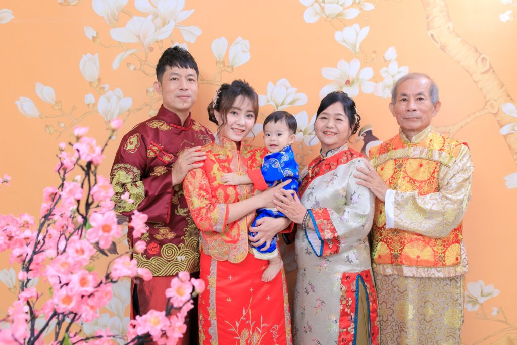 一家人身穿傳統中式服飾於抓周場景拍攝全家福的溫馨畫面