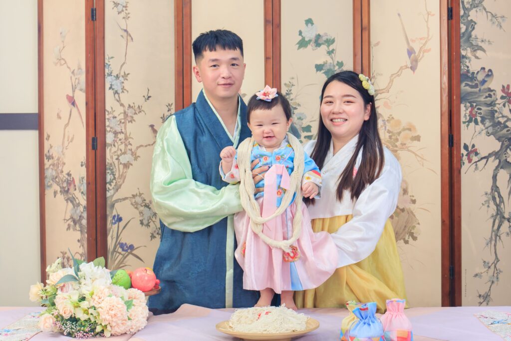 寶寶於韓式抓周場景脖頸掛上長線麵線祈求長壽的儀式畫面